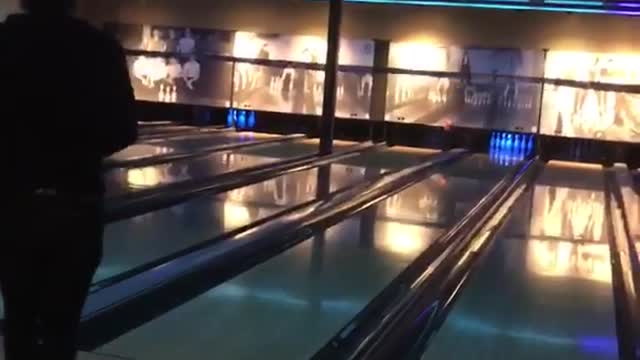 Guy tossing bowling ball and breaking wall