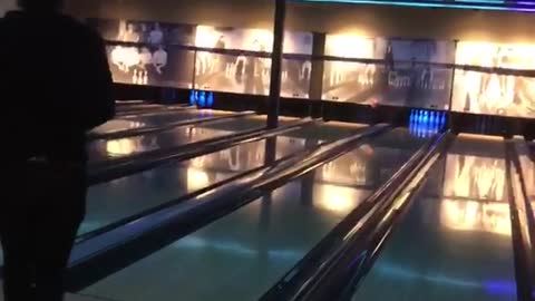 Guy tossing bowling ball and breaking wall