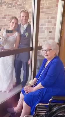 Bride visits her grandmother through glass on wedding day
