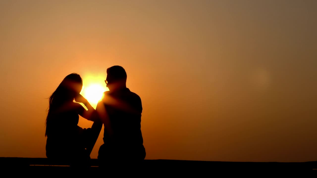 Silhouette of lovers at sunset, static shot