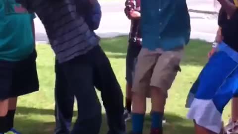 Kids flip a boy in blue he face plants on grass