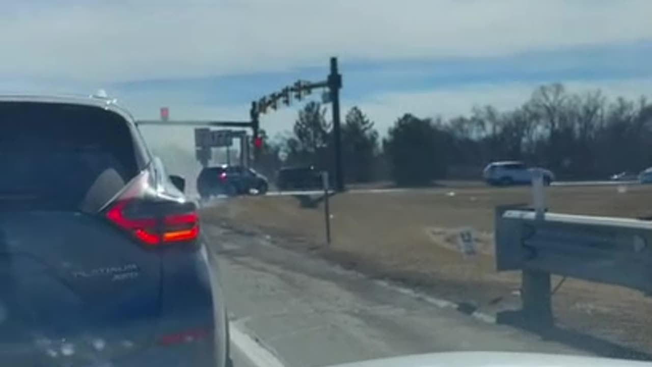 Person Drives a Car Actively on Fire Through Traffic