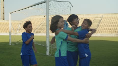 A Group of Boys Running at the Field After Kicking the Ball