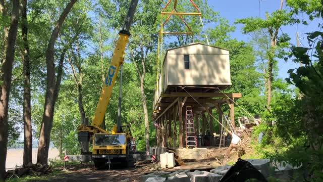 Mobile Home Trailer raised 16' with a crane onto elevated platform on the Ohio River.