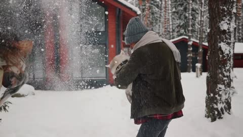 Fearing the snow, the owner is holding his husky in his lap