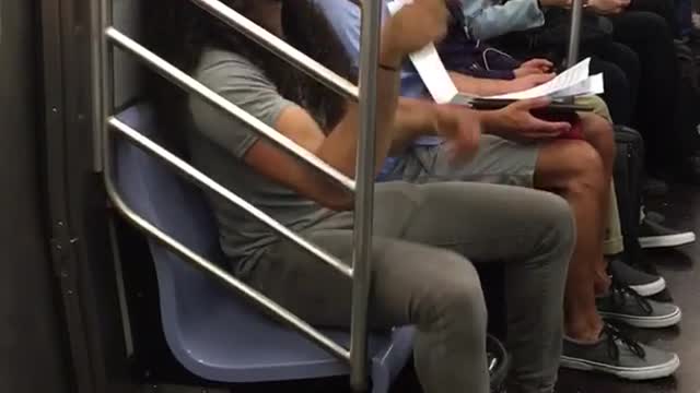 Man with long curly hair bobbing head on train