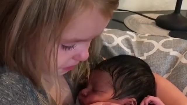 little sister get emotional by holding his baby brother