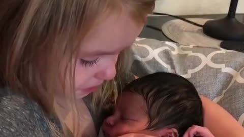 little sister get emotional by holding his baby brother