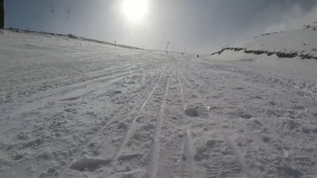 7 guys ride on a sled down the ski slope