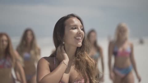 BEAUTIFULL WOMEN WALKS ON THE BEACH WITH THEIR BIKINIS