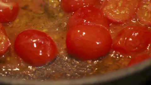 sauteing halves tomatoes on a hot pan