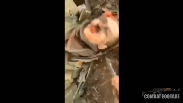 Ukrainian soldier stabbing dead Russian soldier in the face