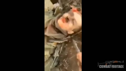 Ukrainian soldier stabbing dead Russian soldier in the face
