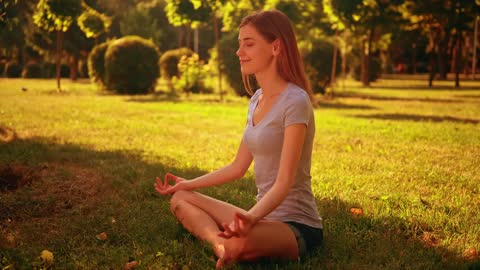 Girl meditating in yoga pose in a park