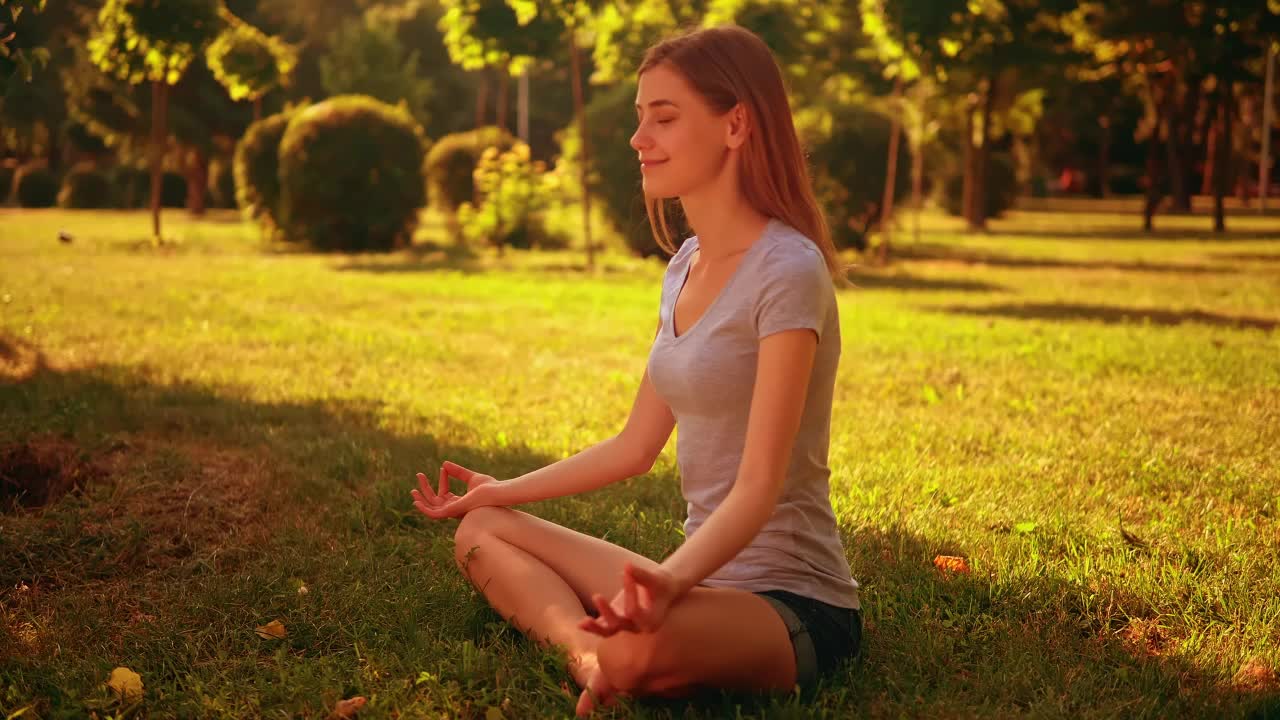 Girl meditating in yoga pose in a park