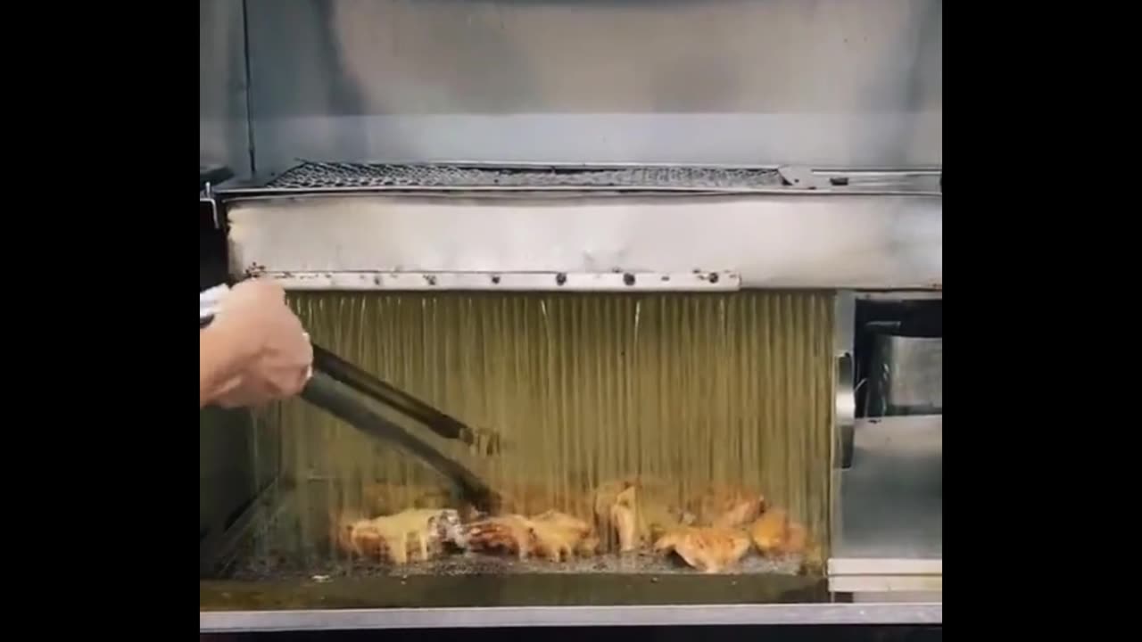 This machine creates a constant "rainfall" of boiling hot oil to keep the coating crispy.