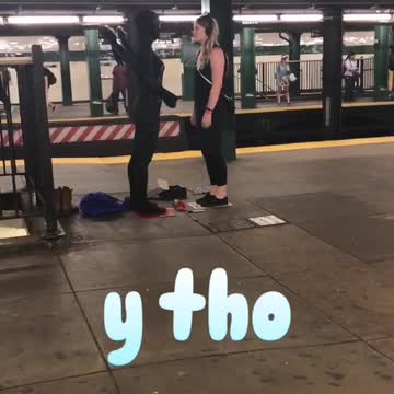 Woman and person in black costume stand off