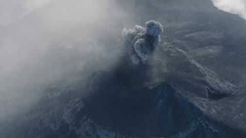 man running towards the erupting volcano
