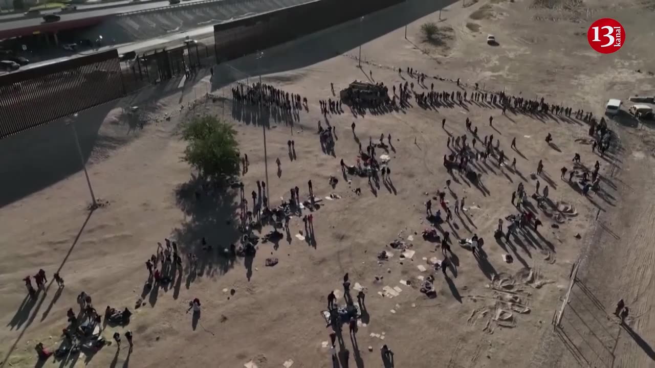 Drone shows hundreds being led through border fence ahead of migrant rule change