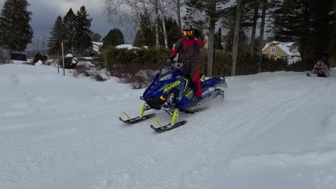 Riding a Snowmoblie in the woods.