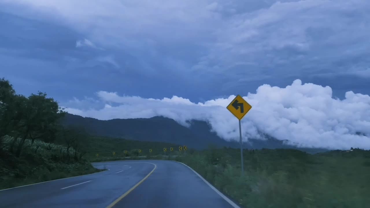 Going down a curved highway through a mountain range