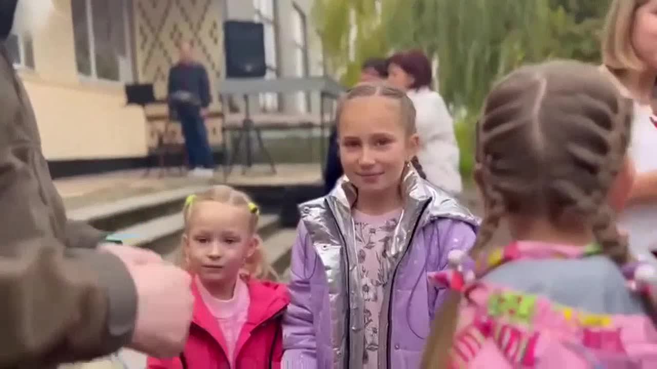 Children tie yellow and blue ribbons to the commander of the Chechen volunteers, Muslim Cheberloevs
