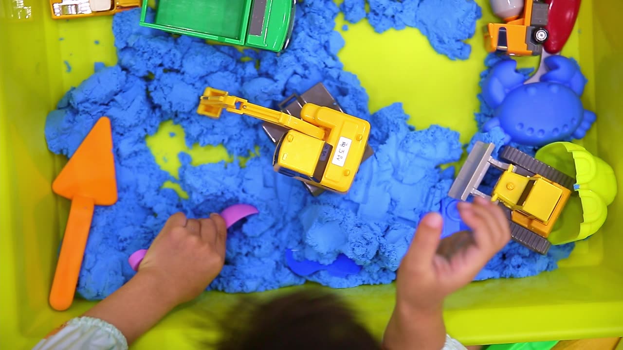 Child's Hand Playing Toy Sand at Home