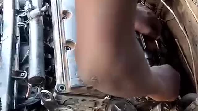 A 12 years old Boy fixing a full engine Car without been supervised