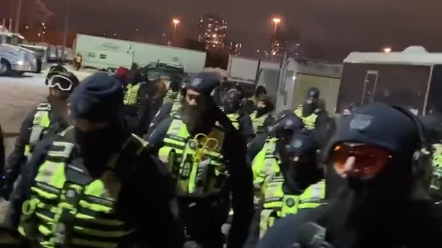 Canadian police march into the trucker camp.