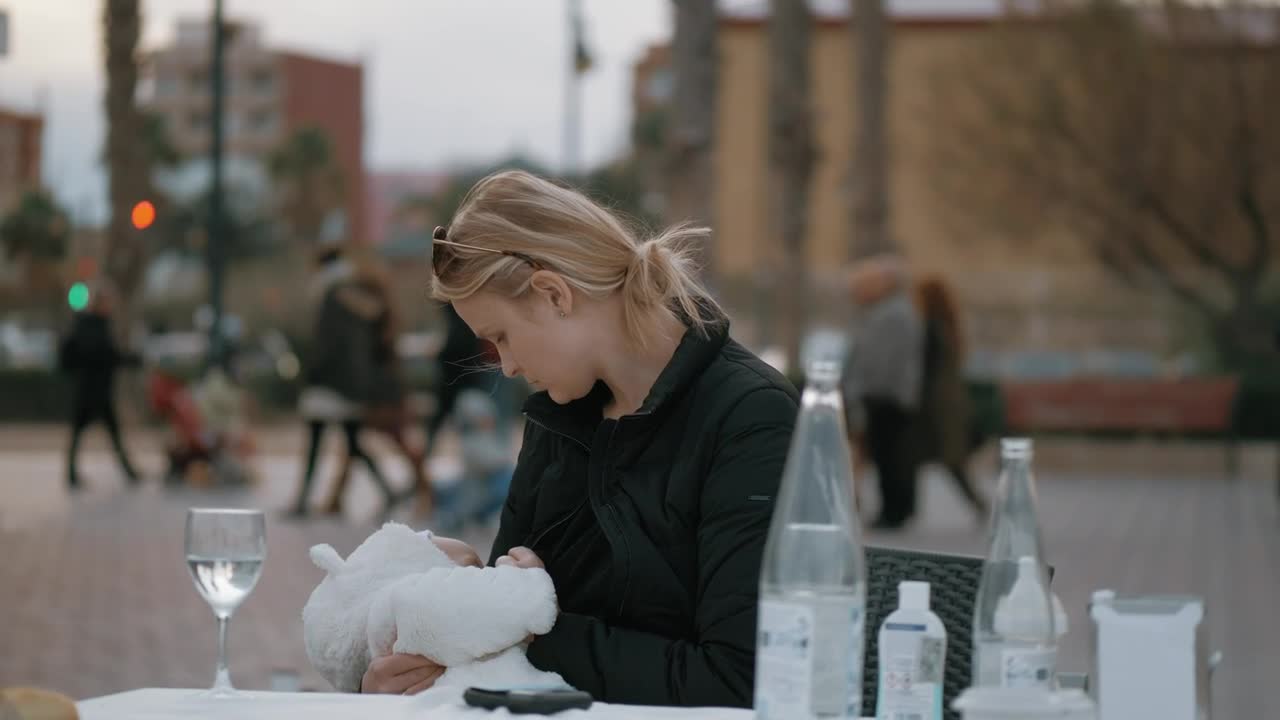 Sitting at a cafe table with her baby