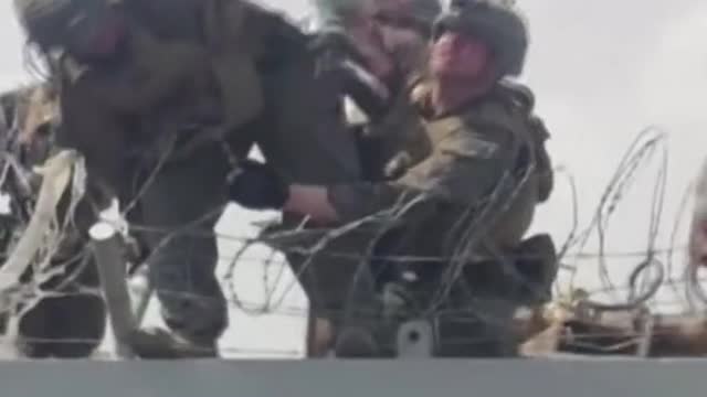 Desperate Afghans pass baby over razor wires to U.S. soldiers