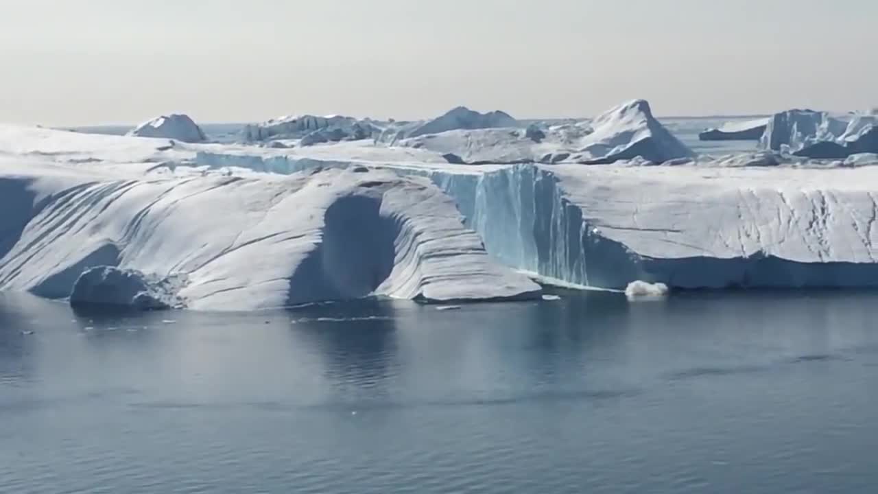 Ilulissat Icefjord - Large iceberg breaking over
