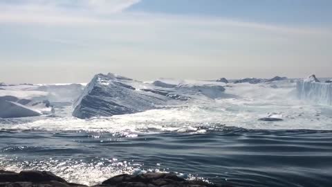 Ilulissat Icefjord - Large iceberg breaking over