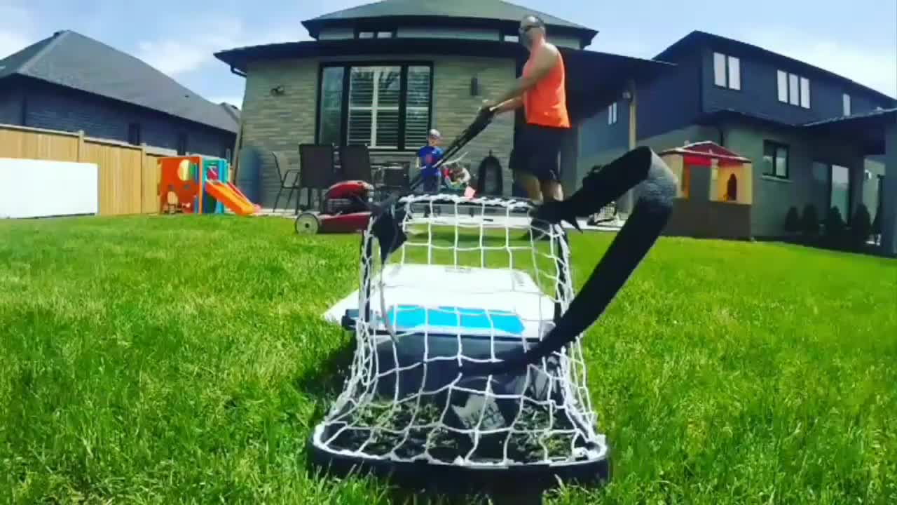 Puck Crosses Over Lawnmower While Dad Cuts Grass After Kid Shoots Hockey Trickshot