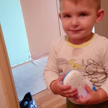 Baby is playing with a toy and smiling