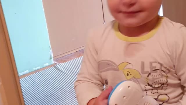 Baby is playing with a toy and smiling