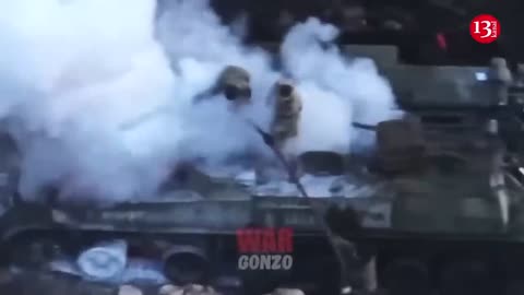 Russians who came to their fellow soldiers’ rescue, seek to put out fire in burning equipment