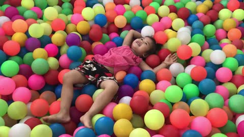 A girl flips through the balls