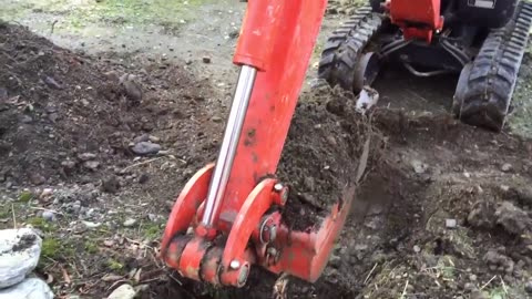 Jims Excavator #44 - Daniel digging out a rock blocking the post hole with the excavator.