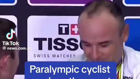 A Paralympic cyclist (with no arms) receives a watch as a trophy gift