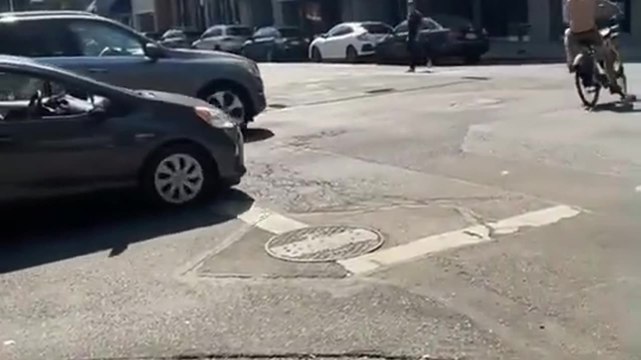 Man riding his bike crashes into a naked guy in front of a store with a giant LGBTQ flag