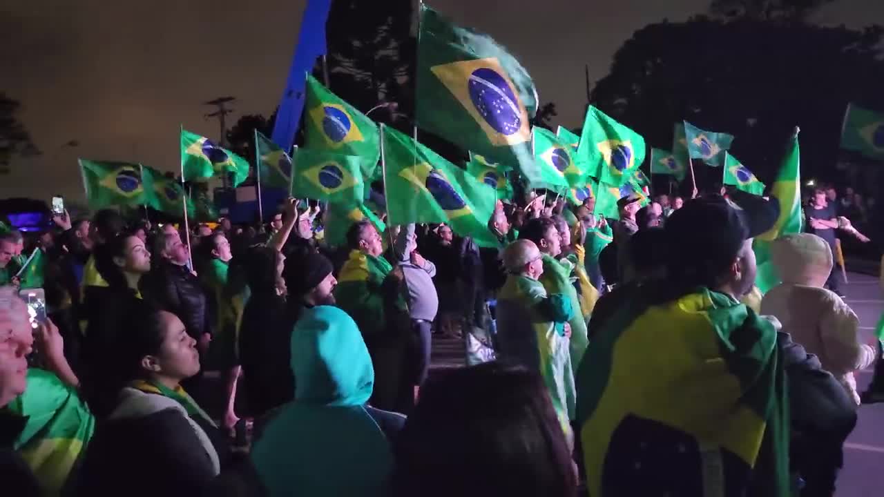 Todos unidos cantando o Hino Nacional em frente ao Exército