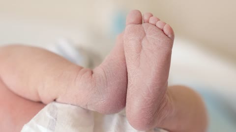 Newborn baby laying on a table