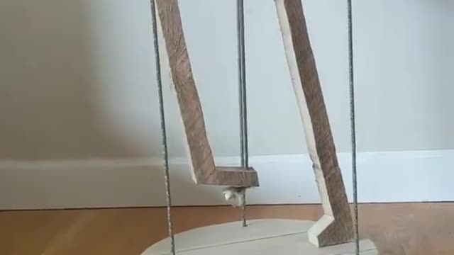 Person Balances Table Over Thin Ropes by Applying Physics Principle of Tensegrity to it