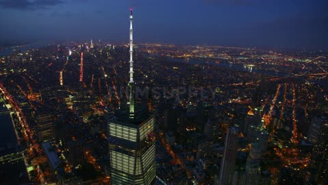 A tall city tower illuminates the night sky