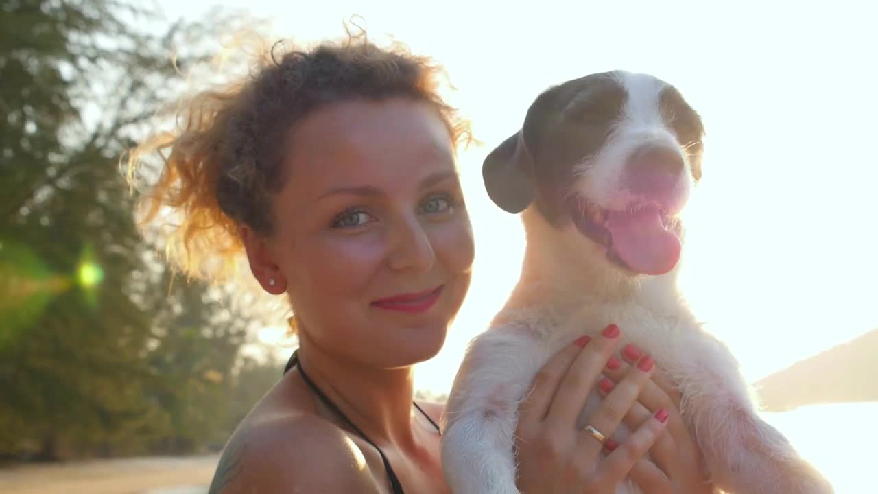 Young Beautiful Woman with Cute Dog on the Beach. Slow Motion