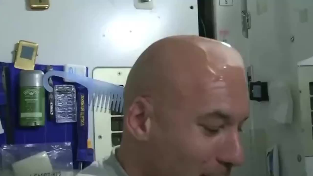 An astronaut washes his hair in space