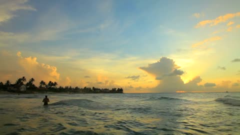 People swimming at sunset