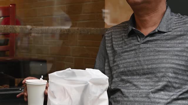 Vertical Video of a Man Having a Coffee Outside of a Coffee Shop