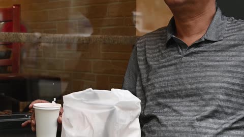 Vertical Video of a Man Having a Coffee Outside of a Coffee Shop